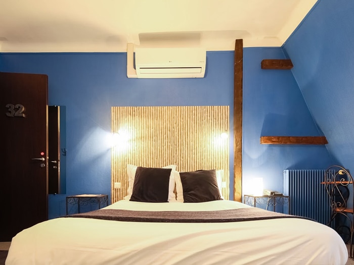 chambre lit double, tête de lit aspect bois tissé mur bleu